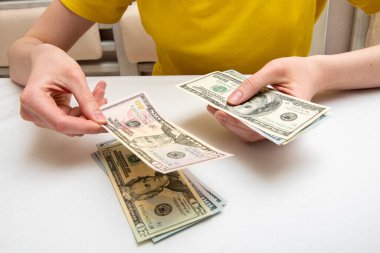 Kadın elleri dolarlarla dolu bir tomarı sayar, bir taraftan diğer tarafa kayar, finansal bağımsızlık kavramı..