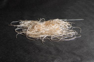 Bir miktar birbirine dolanmış, ince şeftali lifleri. Dikiş işi için, yakın plan, el yapımı. Soyut arkaplan.