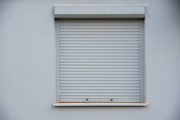 Closed gray blinds on the window. The concept of a problem in the trade or nobody is in the house.
