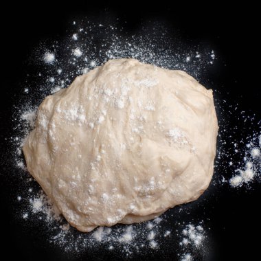 Siyah arka planda hamur ve un yakın plan. Turta ve ekmek için hazırlık. Ev yapımı, yemek pişirme..