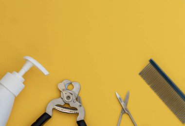 Sarı arka planda klasik bakım ve kuaför aletleri: losyon, sabun, tarak, makas. Üst görünüm, alt yerleşim, düzen, kopyalama alanı