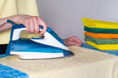 Temiz ve buruşuk bir havlu için buhar ütüleme sistemi olan modern ütülü eller. Ev ödevi konsepti, ev kadını..