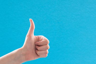 Yakın plan kadın eli baş parmağını kaldırıyor. Olumlu el hareketi, her şey yolunda..