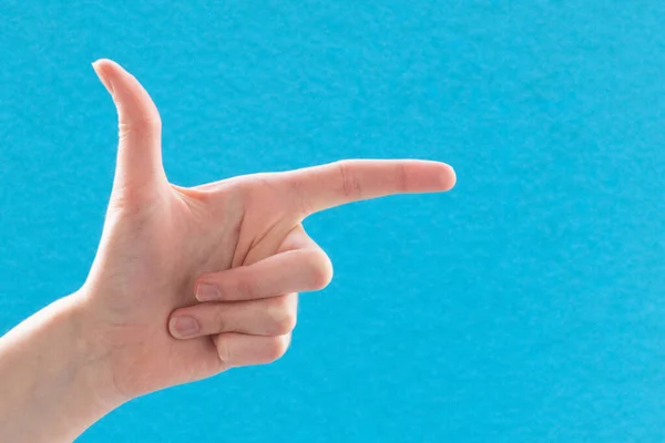 Female Caucasian Hand Blue Background Showing Pistol Gesture Forefinger Forward — Stock Photo, Image