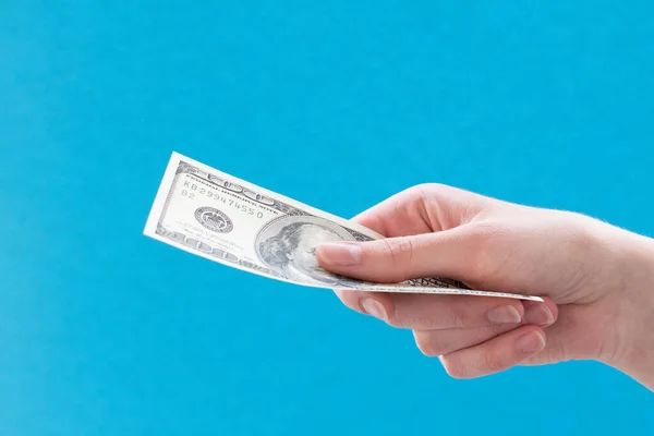 青い背景に100ドル札を与える女性の手のクローズアップ 業務アイデア銀行 — ストック写真