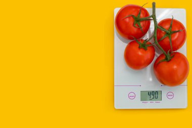 Diyet konsepti, düzgün beslenme, sağlıklı yeme. Mutfak terazisinde taze domates. Tartı ürünleri. Üst görünüm, boşluk kopyala, düzen