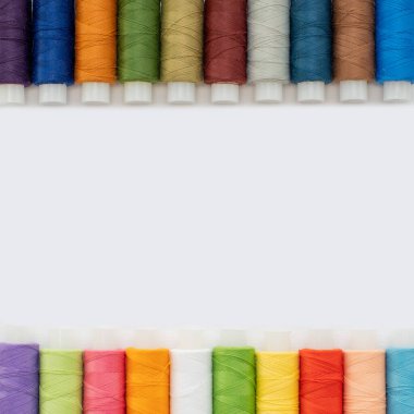 Üst görünüm babunlarda çok renkli iplikler seriyor izole bir arkaplanda iki sıra, kopyalama alanı. İğne işi konsepti, el yapımı, ev yapımı..