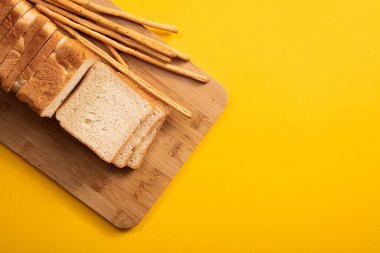 Masanın üstünde kare ekmek ve ekmek kalıpları var. Ekmek kesmek için tahta tahta tahta. Renkli bir masada ekmek..
