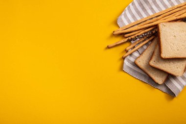 Masadaki ekmek, ekmek çubukları renkli bir arka planda bir kare ekmeğin yanında. Çok yer var.