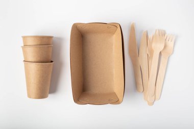 Organik yemekler, ambalajın yukarıdan görünüşü. Tahta çatal ve bıçak, bir bardak. Geri dönüşüm ve çevre dostu tek kullanımlık sofra takımı.