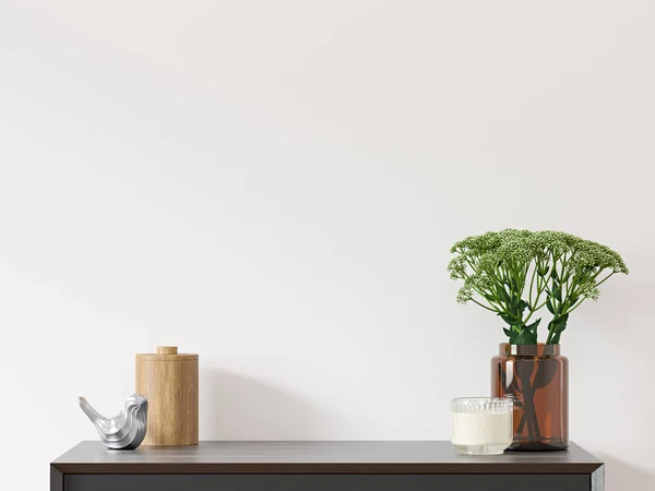 Empty white wall with black dresser, green plant in brown glass vase and decor - close up image.