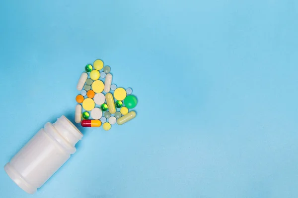 医薬品薬 錠剤とカプセルと青色の背景色の上にボトルを盛り合わせ コピーのテキストのための領域 — ストック写真