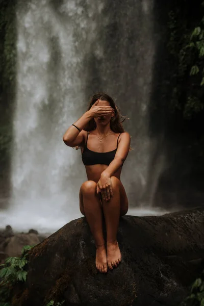 Premium Photo | The girl is engaged in yoga on a background of waterfall  lotus pose