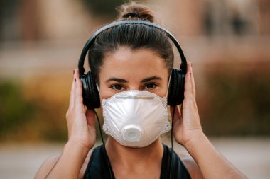Coronavirus hapsi sırasında kız sokakta maskeyle spor yapıyor.