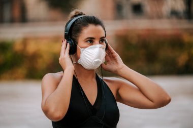 Coronavirus hapsi sırasında kız sokakta maskeyle spor yapıyor.