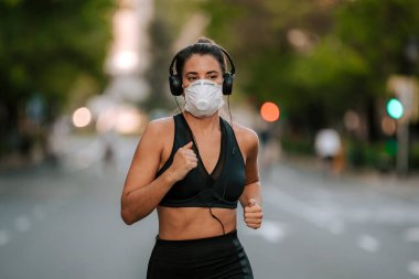 Coronavirus hapsi sırasında kız sokakta maskeyle spor yapıyor.