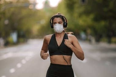 Coronavirus hapsi sırasında kız sokakta maskeyle spor yapıyor.