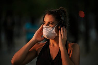 Coronavirus hapsi sırasında kız sokakta maskeyle spor yapıyor.