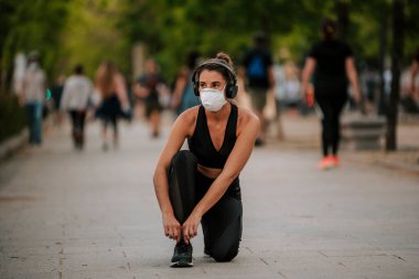 Coronavirus hapsi sırasında kız sokakta maskeyle spor yapıyor.