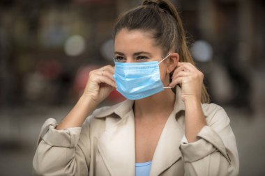 Coronavirus karantinası sırasında kız sokakta maske takıyor.