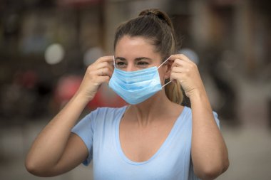 Coronavirus karantinası sırasında kız sokakta maske takıyor.