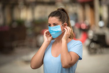 Coronavirus karantinası sırasında kız sokakta maske takıyor.
