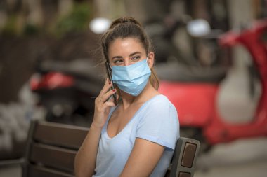 Koronavirüs karantinası sırasında kız sokakta tıbbi maske takıyor.