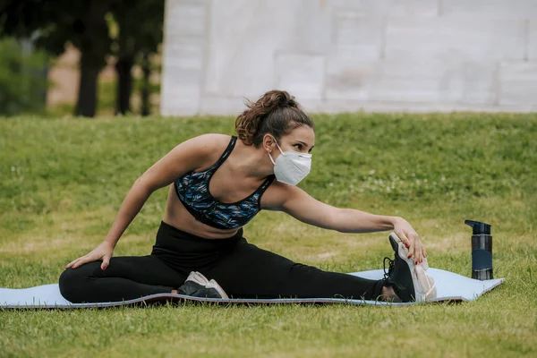 Runner wearing medical mask, Coronavirus pandemic Covid-19. Sport, Active life in quarantine surgical sterilizing face mask protection. Outdoor run on athletics track in Corona Outbreak. yoga park