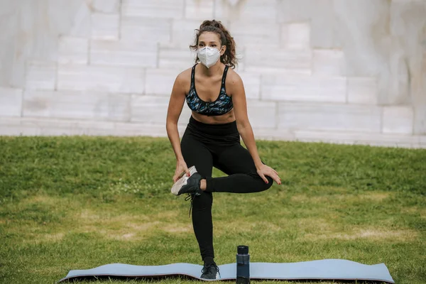 Runner wearing medical mask, Coronavirus pandemic Covid-19. Sport, Active life in quarantine surgical sterilizing face mask protection. Outdoor run on athletics track in Corona Outbreak. yoga park