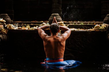 Bali 'deki tapınak. TIRTA EMPUL, tanımlanamayan adam Tiran Empul, Bali, Endonezya 'daki fıskiyelerin kutsal sularında namaz kılıyor ve banyo yapıyor.