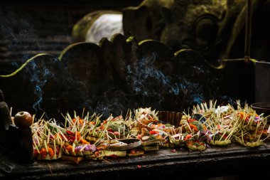 Bali 'deki tapınak. Bali 'de tanrılara çiçek ve aromatik çubuklarla geleneksel bale adağı
