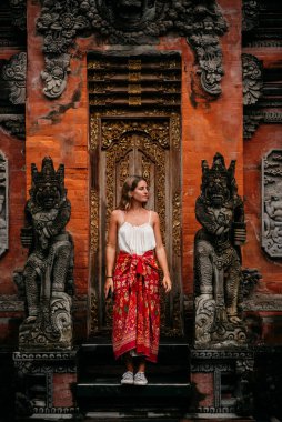 Bali 'deki tapınak. Endonezya 'nın Bali adasındaki Beratan Gölü yakınlarındaki Pura Ulun Danu Bratan tapınağı yakınlarında gün doğumunda genç bir kadın. Bali ve Güneydoğu Asya 'nın ikonik görüntüsü. Seyahat ve macera arkaplan resmi.