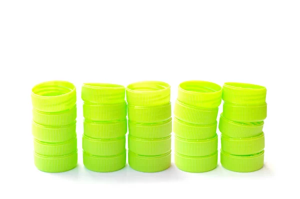 Hromadu zelené plastové láhve víčko na bílém pozadí — Stock fotografie