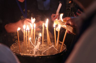 Kudüs 'teki Kutsal Ateş. Bir sürü mum yandı. Resmin odak noktası insanın eli. Vintage fotoğrafçılık.