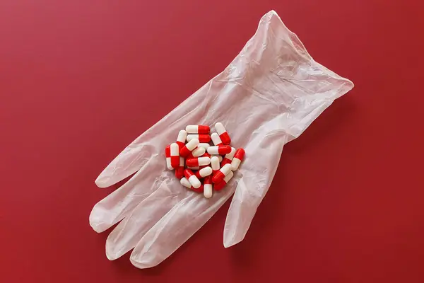 Kırmızı Beyaz Haplar Kapsüller Koruyucu Bir Tıbbi Eldivende Fotoğrafın Koyu — Stok fotoğraf