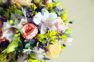 Arka planda yuvarlak bir buket çiçek duruyor. Yumuşacık, bahar, taze bitkilerle birlikte sarı şeftali tonlarında taze. Çok karlı bir buket!