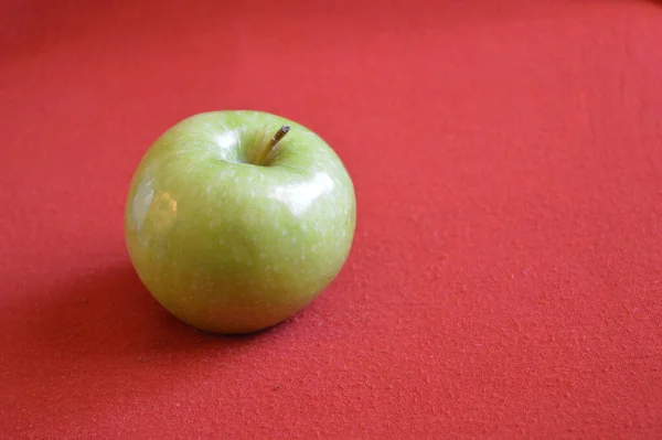 Zielone Jabłko Czerwonym Tle — Zdjęcie stockowe