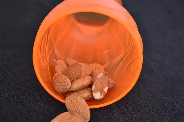 almonds in orange bowl on the black background