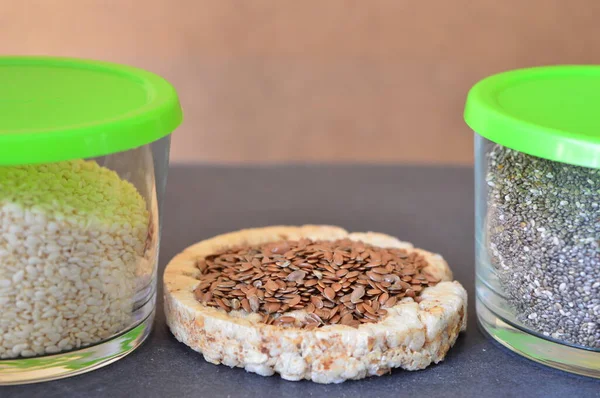 Beyaz ekmeğin üzerinde keten tohumu. Susam ve chia tohumları bir kasede