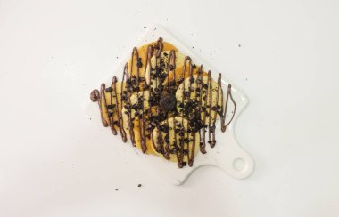 Mini krepli beyaz tabak çikolatalı ve beyaz arka planlı kurabiye.