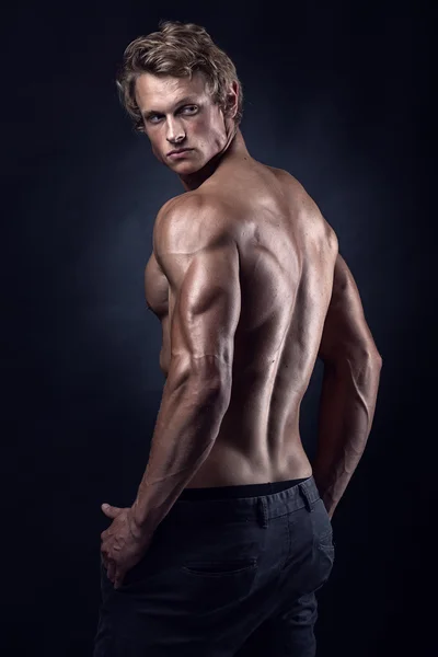 Stark atletisk Man Fitness modell poserar ryggmusklerna Stockbild