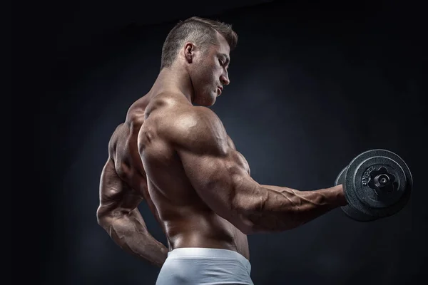 Gespierde bodybuilder man doen oefeningen met dumbbell — Stockfoto