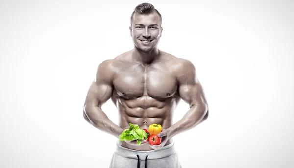 Formad och friska bodybuilder håller en färska grönsaker — Stockfoto