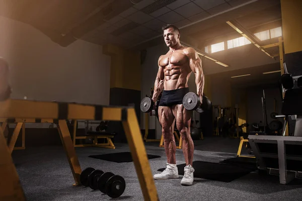 Muscular bodybuilder guy doing exercises with dumbbell — Stock Photo, Image