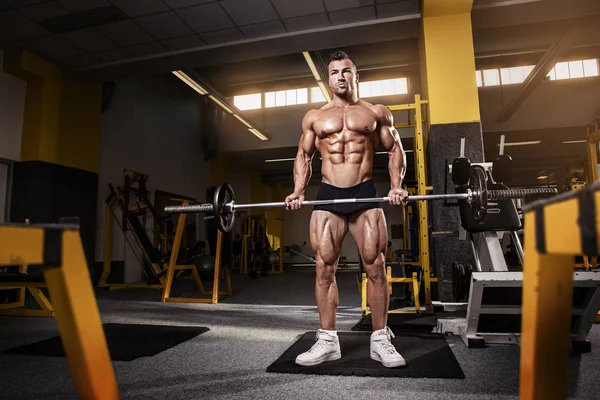 Gespierde bodybuilder man doen oefeningen met dumbbell — Stockfoto