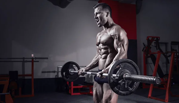 Gespierde bodybuilder man doen oefeningen met dumbbell — Stockfoto