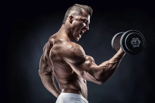 ボディービルダーの筋肉男のダンベルのエクササイズ — ストック写真