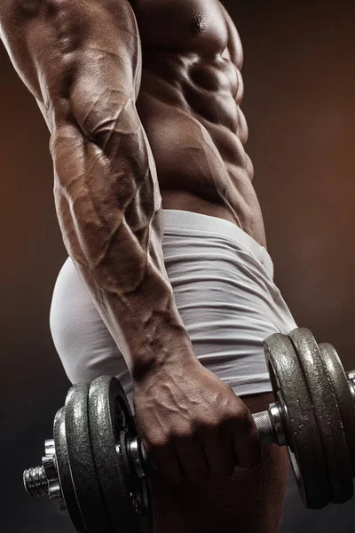 用哑铃锻炼肌肉的健美运动员家伙 — 图库照片