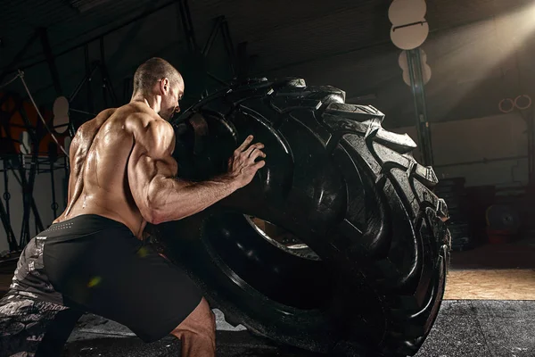 Treinamento de homem forte cruz - homem virando pneu — Fotografia de Stock