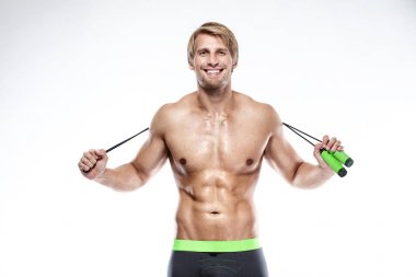 Kaslı vücut geliştirmeci adam ile ip atlama egzersizleri yapıyor